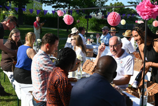 Gäste des Empfangs beim Essen im geschmückten Lorenzpark vor der Kirche