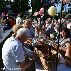 Gäste des Empfangs beim Essen im geschmückten Lorenzpark vor der Kirche